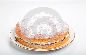 Making sponge cakes, finished cake on a plate with sifted icing sugar