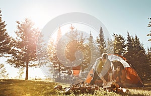 Making sure all the wood is in order. a young married couple camping in the forest.