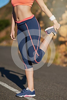 Making sure shes nice and limber. an unrecognizable young woman warming up before a workout.