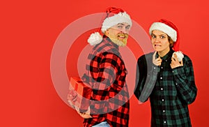 Making surprise. Family shopping. Christmas party. Couple in love with gift. Santa Claus style. Christmas time. Man and