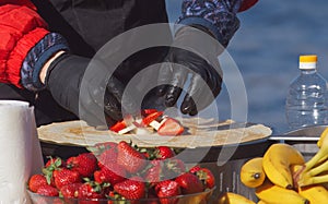 Making sweet fruit crepes, French pancakes at farmers market