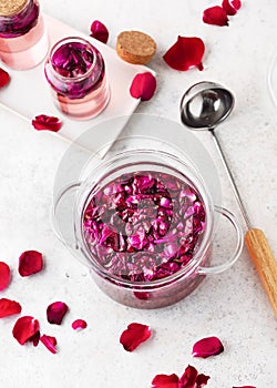 Making sweet syrup, alcoholic beverage liquor or flower flavor wine. Glass pot with boiled organic rose petals.