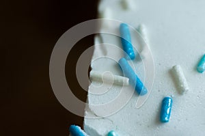 Making sweets at home. Confectionery decorative sprinkling of blue and white on glaze closeup
