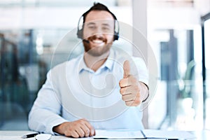 Making swift and successful sales. Closeup shot of a call centre agent showing thumbs up in an office.