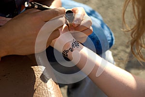 Making temporary, henna tattoo on wirst