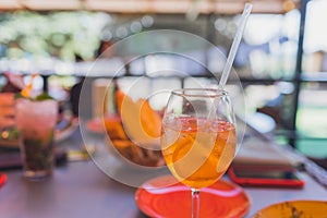 Making Tequila Sunrise Cocktail. Grenadine slowly poured into a glass of ice, orange juice and tequila.