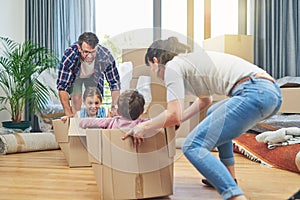 Making the transition into their new home a fun one. a happy family having fun together on moving day.