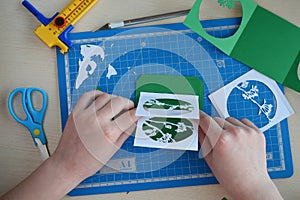 Making tunnelbook. 3D greeting card Spring. Artwork equipment and tools for paper cut - cutting knife, sharp box cutter, blue