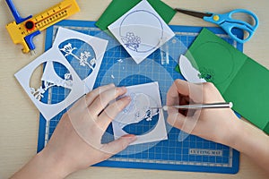 Making tunnelbook. 3D greeting card Spring. Artwork equipment and tools for paper cut - cutting knife, sharp box cutter, blue