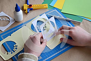 Making  tunnelbook. 3D greeting card `Spring`. Artwork equipment and tools for paper cut - cutting knife, sharp box cutter, blue c