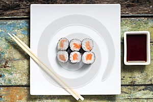 Makisushi on white plate. Seafood traditional maki sushi rolls with chopsticks