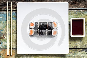 Makisushi on white plate. Seafood traditional maki sushi rolls with chopsticks