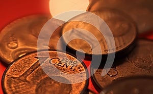 Makro close up of pile one and two euro cent copper coins on shiny red background