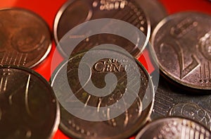 Makro close up of pile one and two euro cent copper coins on shiny red background