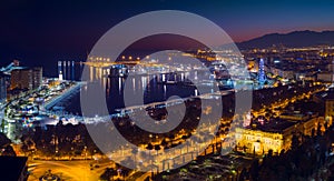 Malaga city with seafront and harbor in the night