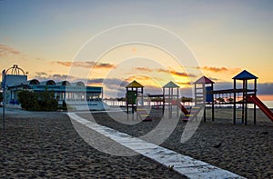 Malaga, Spain - September 02, 2015: Dramatic sunset view of park outdoor on a sandy seashore beach located in Costa del Sol photo