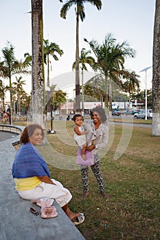 Malagasy beauties, woman with child resting in park