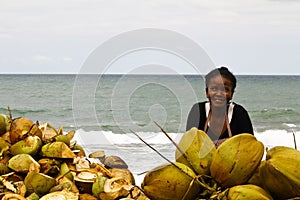 Malagasy woman selling coconuts on the beach