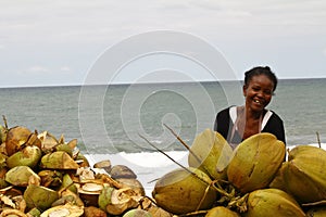 Malagasy woman selling coconuts on the beach