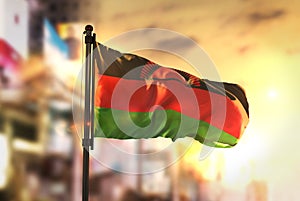 Malawi Flag Against City Blurred Background At Sunrise Backlight