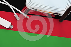 Malawi flag depicted on table with internet rj45 cable, wireless usb wifi adapter and router. Internet connection concept