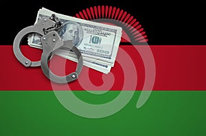 Malawi flag with handcuffs and a bundle of dollars. The concept of breaking the law and thieves crimes