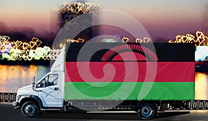 Malawi flag on the side of a white van against the backdrop of a blurred city and river. Logistics concept