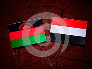 Malawi flag with Yemeni flag on a tree stump