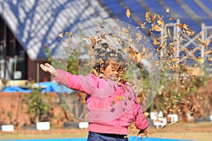 A Malay girl play with autumn dry leaves