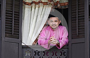 Malay muslim man open a traditional window