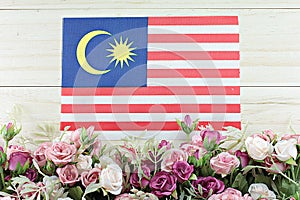 Malaysia flag and flower on wood background
