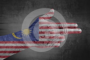 Malaysia flag painted on male hand like a gun