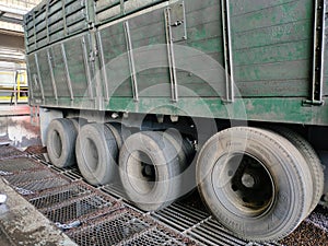 Eight tires on the side of a trailer truck carrying kernal seeds.