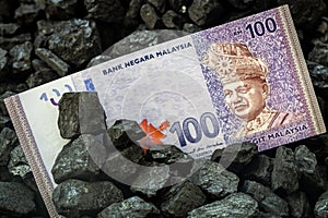 Malaysia money sticking out of coal, 100 ringgit banknote Mining and mining concept in Malaysia, Rising coal prices,