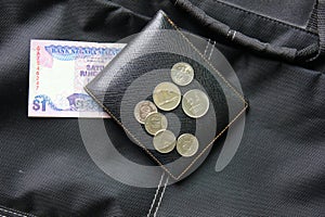 Malaysia ringgit and coins on black wallet.