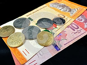Malaysia Ringgit (MYR) Bank Note RM20, RM10 and coins with isolated black background. - Business concept image.