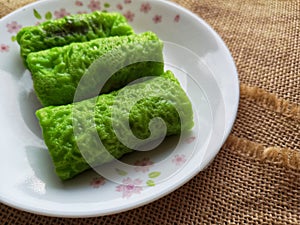 A Malaysia traditional dessert and locally know as Kuih Ketayap served on plate with selective focus.