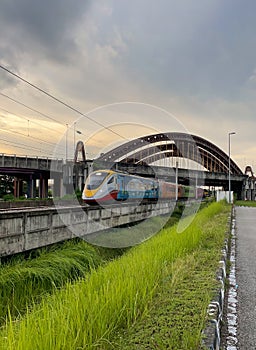 Malaysian eletrical train under the steel bridge photo