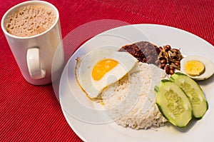 Malaysian Food - Nasi Lemak and Frothy Teh Tarik on a red background. Both dishes are unofficially the national breakfast dish