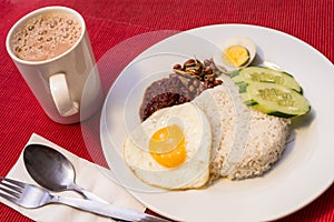 Malaysian Food - Nasi Lemak and Frothy Teh Tarik on a red background. Both dishes are unofficially the national breakfast dish