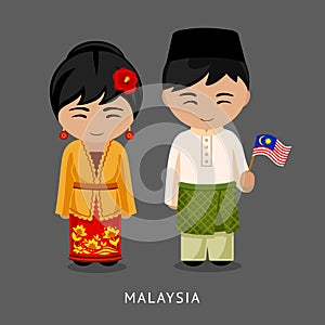 Malaysians in national dress with a flag.