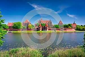 Malbork castle by the Nogat river at summer, Poland photo