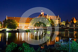 Malbork castle over the Nogat river at night, Poland photo