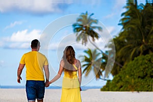 Maldives, a couple walking along the beach hand in hand