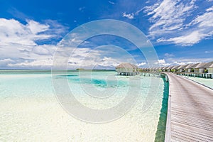 Maldives island, luxury water villas resort and wooden pier jetty. Beautiful sky and ocean lagoon beach. Summer scenic