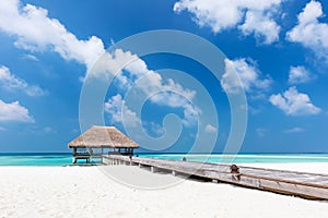 Maldives islands. Wooden jetty with water relaxation lodge.