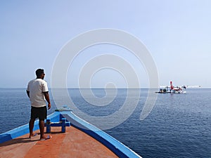 MALDIVES - JULY 17, 2017: Angaga island resort & spa`s staff aboarding a resort boat, which take departing customers to seaplane