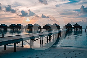Maldives sunset or sunrise with water villas silhouette