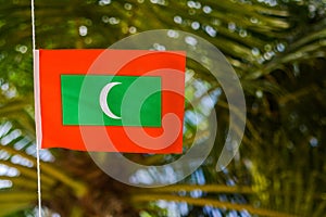 Maldivian red green colour national flag on the rope during windy day