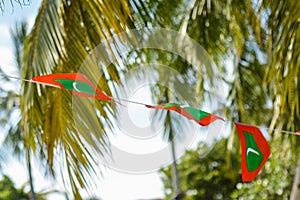 Maldivian red green colour national flags on the rope during beautiful windy day